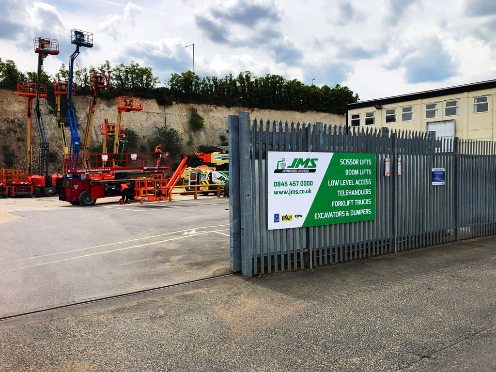 JMS Dartford depot gate with view of machines