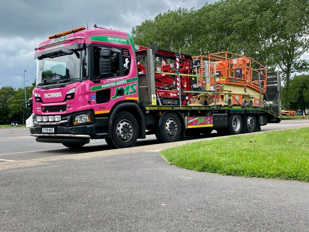 Truck loaded with Hinowa spider lift and scissor lifts